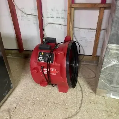 Wet-dry extractor pulling water off a living room floor after a storm