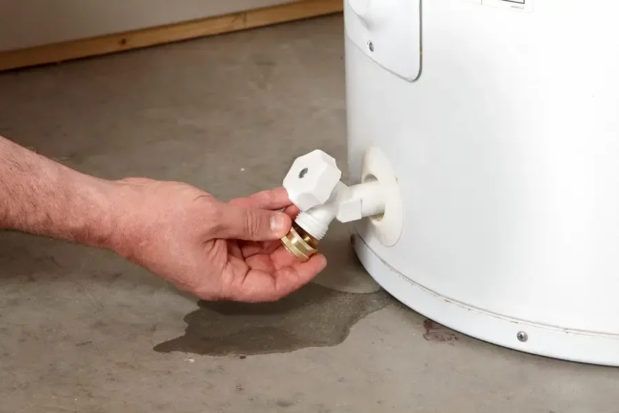 A water heater leaking across a basement floor